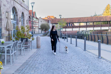 Frau mit Hund auf dem Uferweg vor dem Hotel Alter Packhof