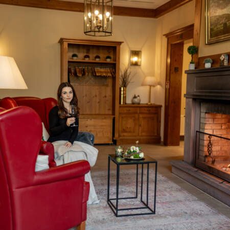 Frau mit Getränk in der gemütlichen Kamin-Lounge des Hotel Alter Packhof