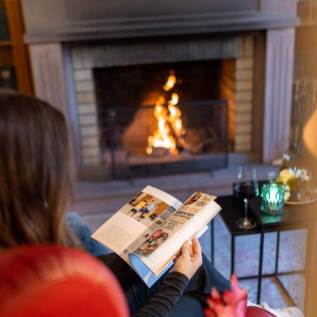 Gast beim Lesen vor dem Kamin in der Lounge des Hotel Alter Packhof