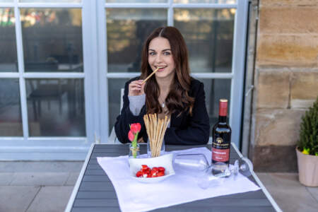 Frau auf der Terrasse des Hotel Alter Packhof mit Wein und kleinen Snacks