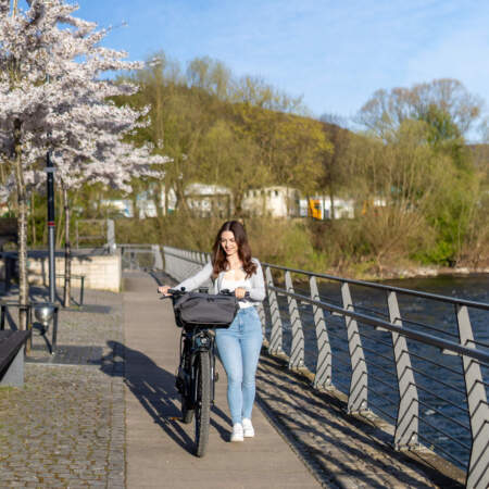 Gast mit Fahrrad auf dem Uferweg nahe dem Hotel Alter Packhof